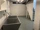 Unfinished basement featuring utility sink and stairwell to the main floor at 937 N Bosart Ave, Indianapolis, IN 46201