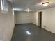 Unfinished basement with painted floor and block wall with door to another room at 937 N Bosart Ave, Indianapolis, IN 46201