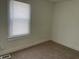 Cozy bedroom with carpet flooring, a bright window, and neutral walls at 937 N Bosart Ave, Indianapolis, IN 46201