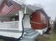 This Craftsman home boasts a quaint front porch with a new railing system, painted steps, and updated landscaping at 937 N Bosart Ave, Indianapolis, IN 46201