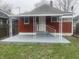 This bungalow-style home features a quaint covered front porch with a new railing and updated stairs at 937 N Bosart Ave, Indianapolis, IN 46201