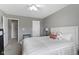 Neutral bedroom with white bedding, bedside table with lamp, and doors at 9694 Angelica Dr, Noblesville, IN 46060