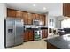 This kitchen features stainless steel appliances, stone countertops and warm wood cabinetry at 9694 Angelica Dr, Noblesville, IN 46060
