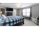 The primary bedroom offers a plaid duvet and neutral walls and carpeting at 9694 Angelica Dr, Noblesville, IN 46060