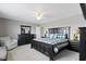 The primary bedroom features a plaid duvet, fan and a gray armchair at 9694 Angelica Dr, Noblesville, IN 46060
