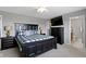 The primary bedroom offers a plaid duvet, fan and access to an ensuite bathroom at 9694 Angelica Dr, Noblesville, IN 46060
