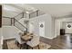 Open-concept dining area with staircase access, a view of the front door, and laminate flooring at 10237 Sand Run Ln, Fortville, IN 46040