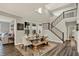 Bright dining room with large windows, a farmhouse table, bench seating, and views of the staircase at 10237 Sand Run Ln, Fortville, IN 46040
