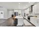 Open kitchen with stainless appliances, center island with seating, and views into the dining room at 10237 Sand Run Ln, Fortville, IN 46040