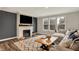 Elegant living room with a cozy fireplace, large windows, and plush sectional seating at 10237 Sand Run Ln, Fortville, IN 46040