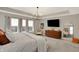 Bright primary bedroom offers tray ceiling, contemporary dresser, and a cozy chair at 10237 Sand Run Ln, Fortville, IN 46040