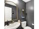 Stylish powder room featuring dark grey walls, a gold-framed mirror, and unique geometric shelves at 10237 Sand Run Ln, Fortville, IN 46040