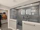 Modern tiled shower in bathroom with glass surround and bench seat, open to walk-in closet at 10237 Sand Run Ln, Fortville, IN 46040