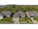 Aerial view of the home's brick facade, two-car garage, driveway, and lush, mature landscaping at 11598 Platt St, Noblesville, IN 46060