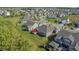 High angle aerial view of multiple homes showing rooftops, tree coverage, a red umbrella, and green lawns at 11598 Platt St, Noblesville, IN 46060
