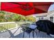 Outdoor deck featuring a black table and chairs, perfect for al fresco dining under a red umbrella at 11598 Platt St, Noblesville, IN 46060
