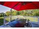 Outdoor deck featuring a black table and chairs, perfect for al fresco dining under a red umbrella at 11598 Platt St, Noblesville, IN 46060