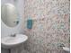 Half bathroom featuring patterned wallpaper, a pedestal sink, a round mirror, and modern fixtures at 11598 Platt St, Noblesville, IN 46060