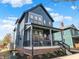 Charming two-story home with a covered front porch and dark blue siding against a bright blue sky at 1238 Alabama St, Indianapolis, IN 46202
