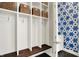 Well-organized mudroom includes built-in storage, a bench, hooks, and a view of the colorful powder room at 1238 Alabama St, Indianapolis, IN 46202