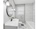 Bathroom featuring a modern vanity, a round mirror, and a shower/tub combo with stylish tile at 1241 Brandt Dr, Indianapolis, IN 46241