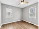 Bedroom with hardwood floors, neutral gray walls and trim, ceiling fan and two windows for natural light at 1241 Brandt Dr, Indianapolis, IN 46241