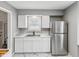 Bright kitchen with stainless steel refrigerator, white cabinets, marble-look counters and stylish marble floors at 1241 Brandt Dr, Indianapolis, IN 46241
