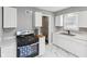 Modern kitchen with stainless steel appliances, white cabinets, and marble tile flooring at 1241 Brandt Dr, Indianapolis, IN 46241