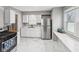 Bright kitchen featuring stainless steel appliances, white cabinets, and marble-look tile floors at 1241 Brandt Dr, Indianapolis, IN 46241