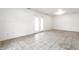 Clean basement space with tile floors, white wainscoting, and a double-door entry to outside at 1252 Kappes St, Indianapolis, IN 46221