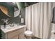 Charming bathroom with a white vanity, oval mirror, toilet, and white patterned shower curtain at 1252 Kappes St, Indianapolis, IN 46221