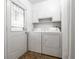 Functional laundry room with white cabinets, washer, dryer, and a leaded-glass door at 1252 Kappes St, Indianapolis, IN 46221