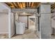 Basement laundry area with washer, dryer, and access to the rest of the unfinished basement at 1330 N Gibson Ave, Indianapolis, IN 46219
