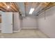Unfinished basement with exposed ceiling, concrete floor, and a door that leads to another room at 1330 N Gibson Ave, Indianapolis, IN 46219