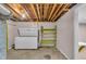 Unfinished basement featuring an extra refrigerator and storage shelves perfect for organization and storage at 1330 N Gibson Ave, Indianapolis, IN 46219