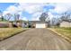 One-story home featuring a spacious driveway, attached garage, and brick accents at 1330 N Gibson Ave, Indianapolis, IN 46219
