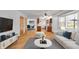 Bright living room featuring hardwood floors, modern furnishings, and an open layout connecting to dining and kitchen areas at 1330 N Gibson Ave, Indianapolis, IN 46219