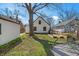 Backyard view with a detached garage, garden beds, and a gravel patio area at 136 W 43Rd St, Indianapolis, IN 46208
