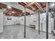 Unfinished basement with painted walls and floors, a washer and dryer, and visible ceiling beams at 136 W 43Rd St, Indianapolis, IN 46208