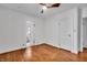 Sunny bedroom with hardwood floors, ceiling fan, and a doorway to an ensuite bathroom at 136 W 43Rd St, Indianapolis, IN 46208