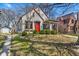 Quaint home featuring a bright red door, established greenery, and a detached garage at 136 W 43Rd St, Indianapolis, IN 46208