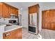 Traditional kitchen with stainless steel appliances, wood cabinets, and white tile flooring at 136 W 43Rd St, Indianapolis, IN 46208