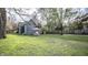 Wide shot of a well-maintained yard with a table and chairs set, set against mature trees at 1542 Maple Ave, Noblesville, IN 46060