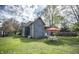 Wide shot of a well-maintained yard with a table and chairs set, set against mature trees at 1542 Maple Ave, Noblesville, IN 46060