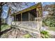 A charming bungalow home featuring a covered porch, contrasted against a lush yard with mature trees at 1542 Maple Ave, Noblesville, IN 46060