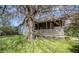 A charming bungalow home featuring a covered porch, contrasted against a lush yard with mature trees at 1542 Maple Ave, Noblesville, IN 46060
