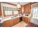 Quaint kitchen with wood cabinets, tile countertops, and vintage-style lighting fixtures at 1542 Maple Ave, Noblesville, IN 46060