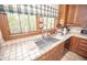 Bright kitchen with tile countertops, a large window offering a scenic view, and ample natural light at 1542 Maple Ave, Noblesville, IN 46060