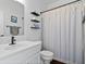 Well-lit bathroom featuring a white vanity, toilet, and shower with a decorative curtain at 16566 Branham Dr, Fishers, IN 46040