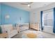 Bright Bedroom featuring a crib, changing table, and blue accent wall with wave decals at 16566 Branham Dr, Fishers, IN 46040